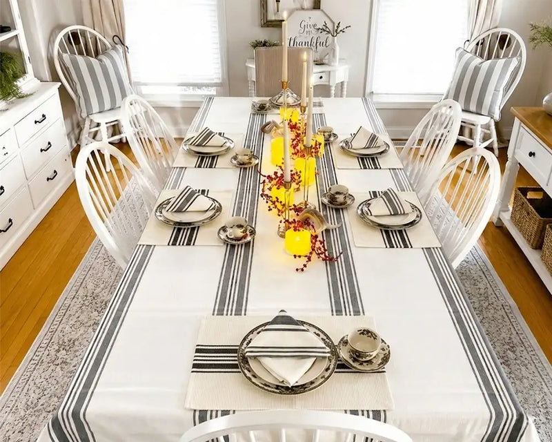 Dining room with a set table featuring striped tablecloth and decorative elements.