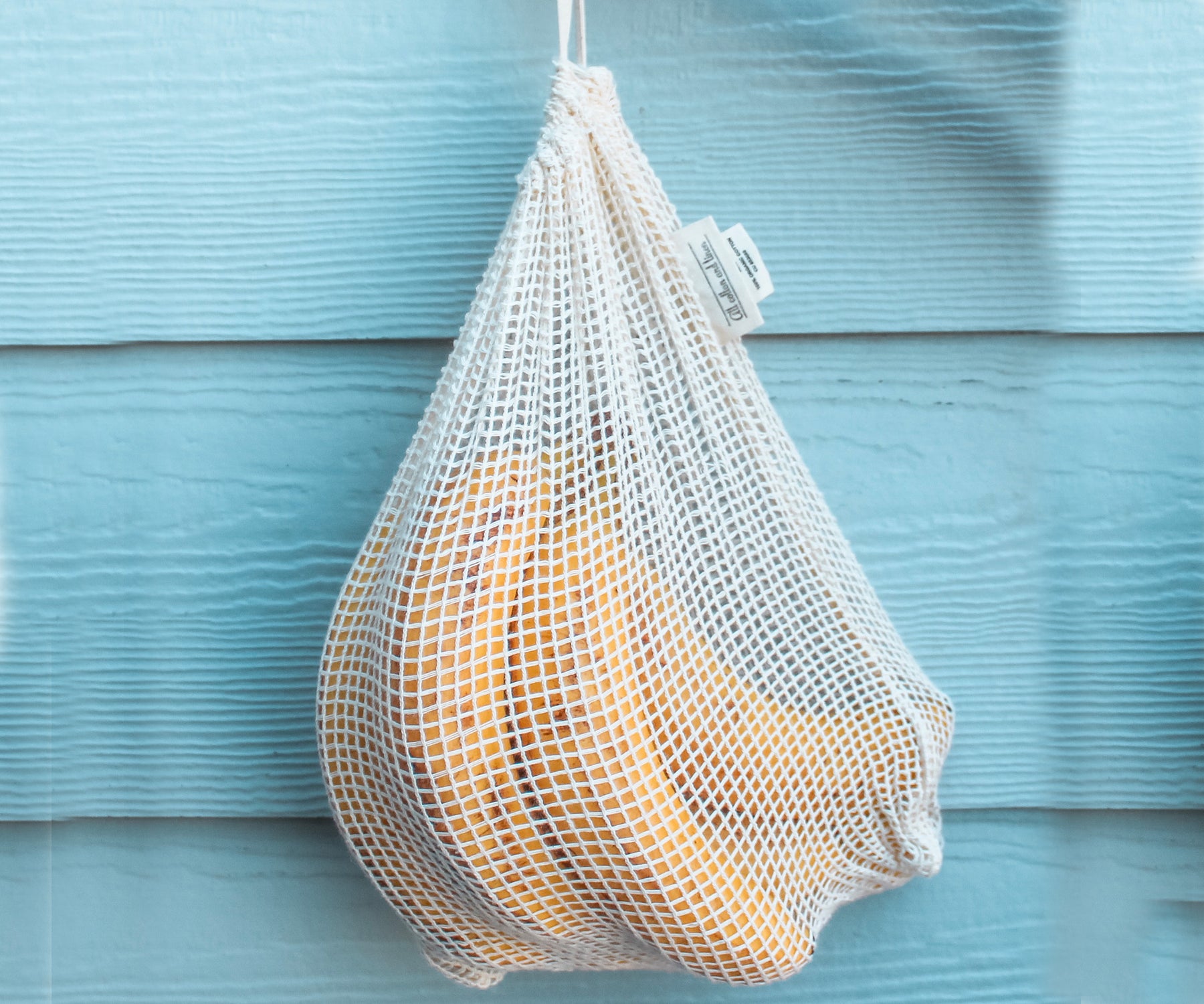 Bananas stored neatly in a reusable mesh produce bag