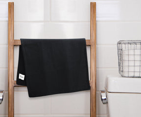 Black and white striped towel draped over a ladder in a home setting