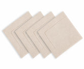 Natural color hemstitched cotton linen blend dinner napkins arranged on an elegant dining table with classic dinnerware and neutral table decor