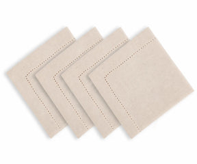 Natural color hemstitched cotton linen blend dinner napkins arranged on an elegant dining table with classic dinnerware and neutral table decor