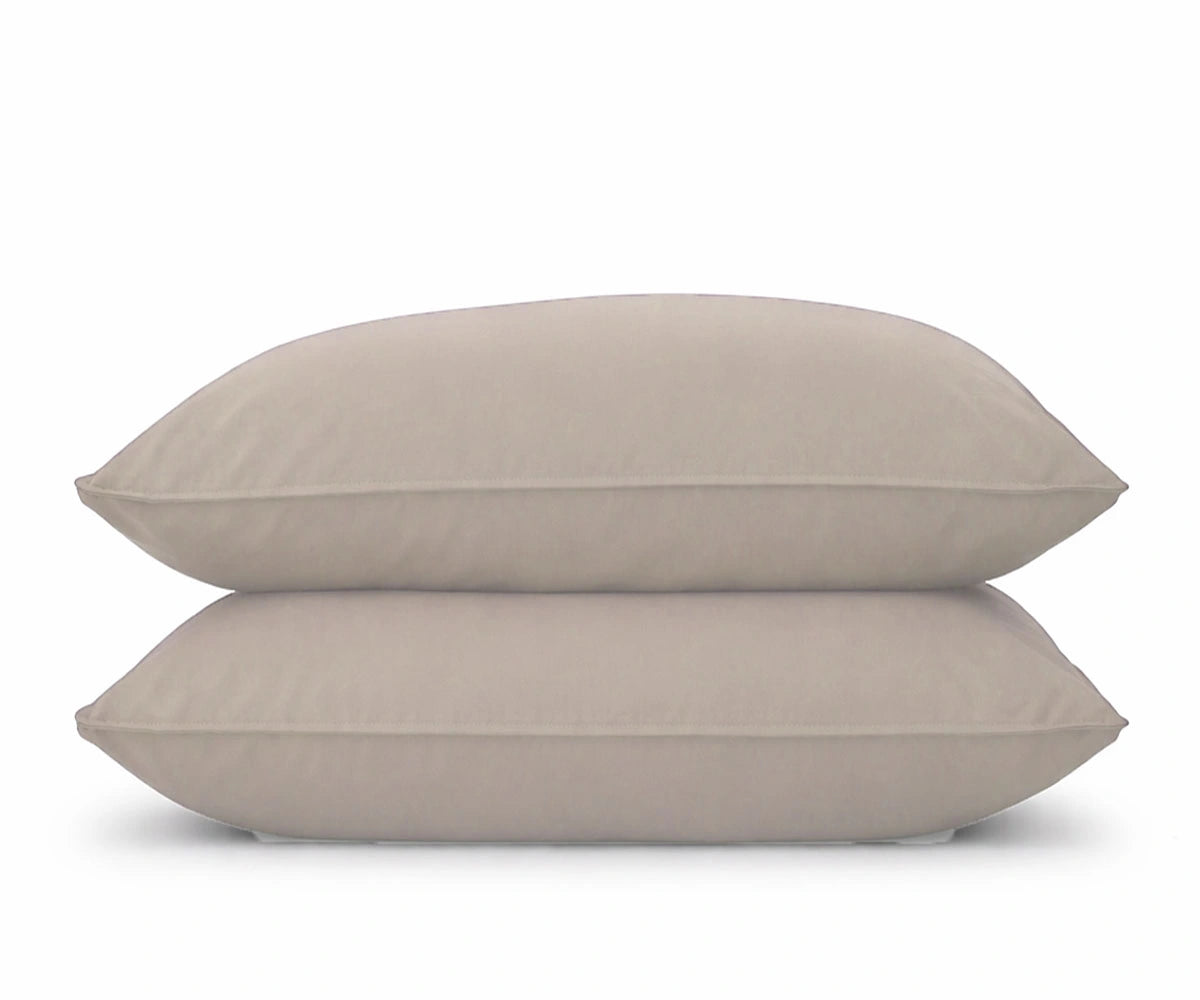 A set of two natural -colored pillowcases stacked on a white background, perfect for an organic, earthy bedroom aesthetic.