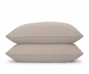 A set of two natural -colored pillowcases stacked on a white background, perfect for an organic, earthy bedroom aesthetic.