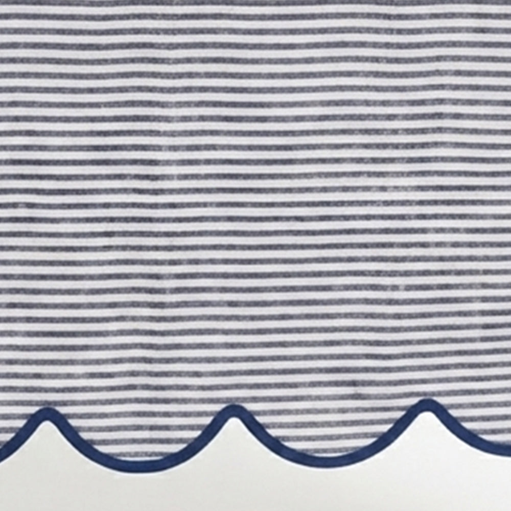 Close-up of navy blue and white thin striped linen tablecloth fabric highlighting the decorative navy scalloped edge border.