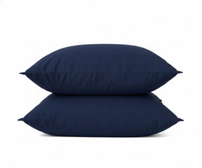 Navy blue linen pillowcases stacked on top of each other, showcasing soft fabric detail.