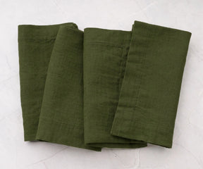 Folded olive green cotton linen napkins with minimalist solid design, reusable dinner napkins