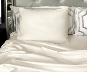 Bed adorned with white cotton fitted sheets and pillows