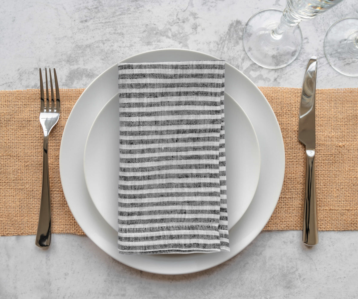 Reusable linen cloth napkins featuring a classic black stripe pattern for contemporary table decor
