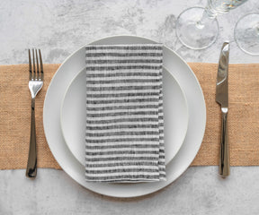 Reusable linen cloth napkins featuring a classic black stripe pattern for contemporary table decor