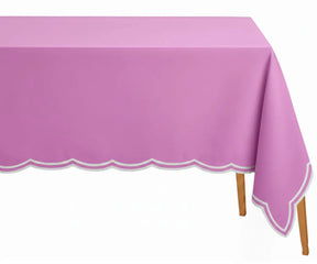 Pink rectangle tablecloth with white scalloped embroidery on a dining table