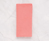 Set of 12 pink cotton napkins in 100% cotton, neatly folded on a dining table with a matching pink cotton tablecloth.