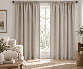 Pair of flax  plain cotton curtains hanging on a dark rod in a bright living room.