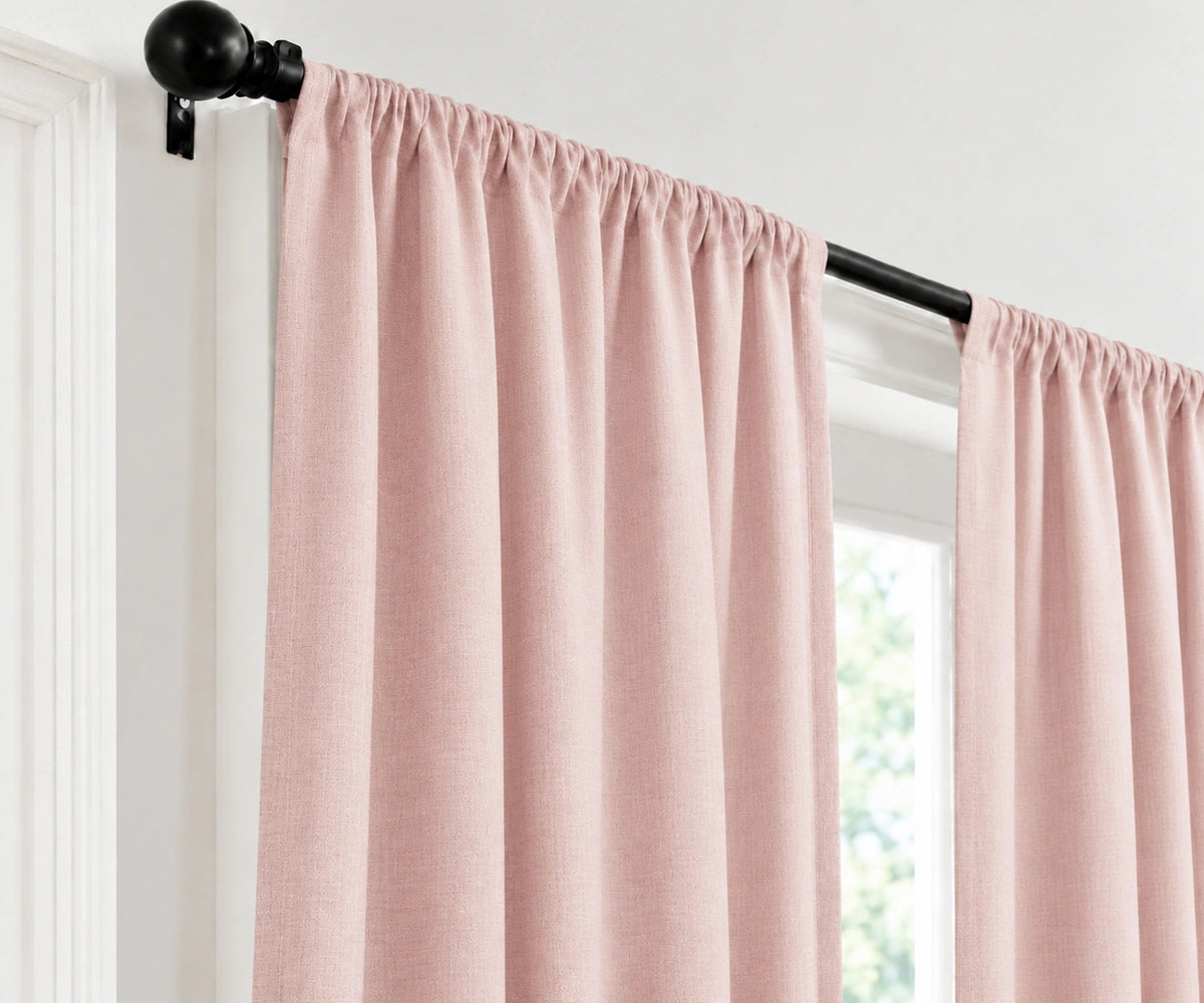 A pair of  rose curtain panels hanging from a black metal rod with a decorative finial, shown in a window setting.
