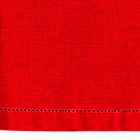 Close-up of red cotton linen tablecloth with a detailed hemstitched border.