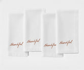 Classic white dinner napkin featuring stylish ‘Thankful’ stitched lettering.