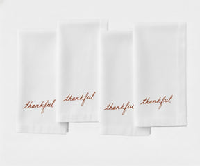 Classic white dinner napkin featuring stylish ‘Thankful’ stitched lettering.
