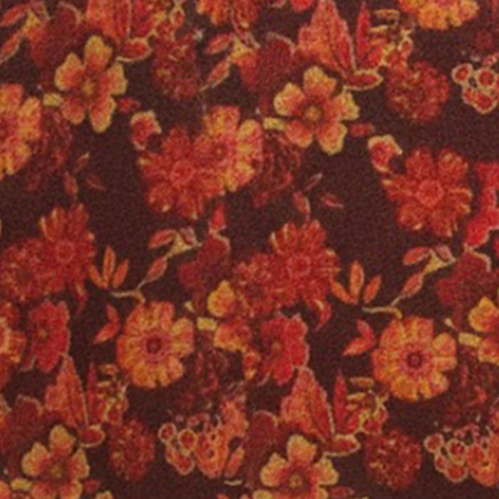 Orange and red floral block print tablecloth draped on wooden table