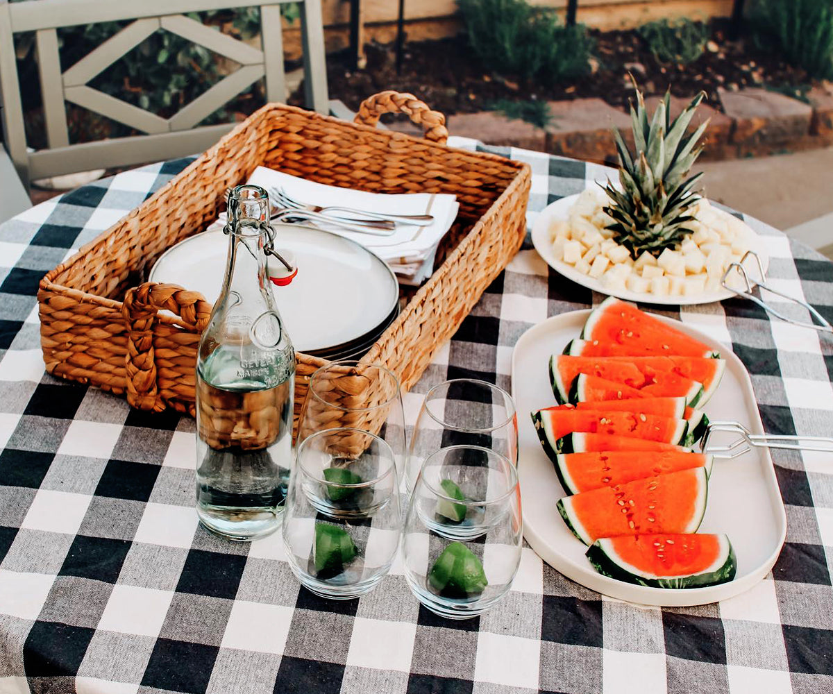 Summer picnic table with a black checkered tablecloth and watermelon slices