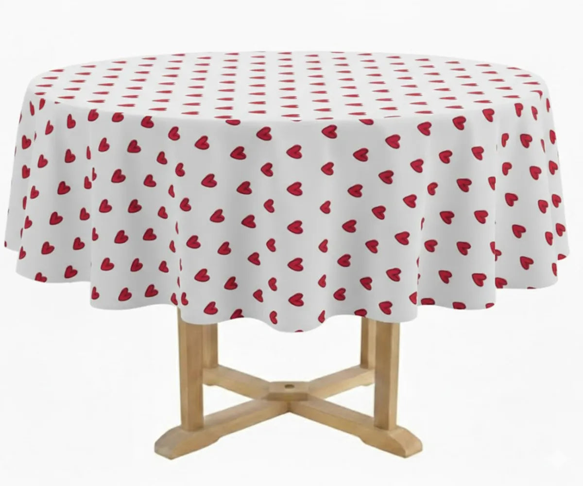 Red heart printed cotton tablecloth styled on round dining table for Valentine’s Day décor.