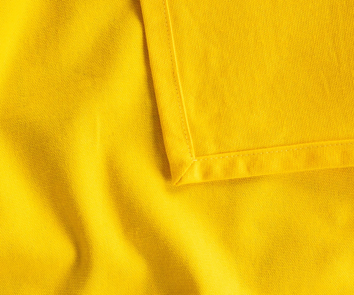 Soft, durable yellow cotton tablecloth in multiple sizes, ideal for restaurants, holiday meals, or casual family dining, eco-friendly and timeless design.