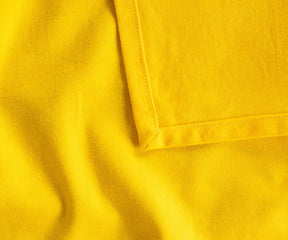 Soft, durable yellow cotton tablecloth in multiple sizes, ideal for restaurants, holiday meals, or casual family dining, eco-friendly and timeless design.