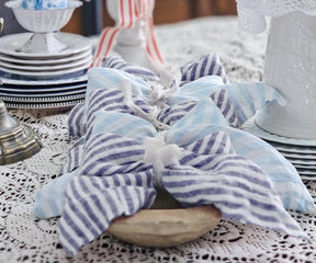 Reusable blue pinstripe linen napkins designed for sustainable entertaining and stylish table settings