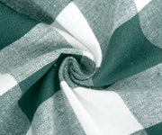 Round green and white checkered tablecloth on wooden table
