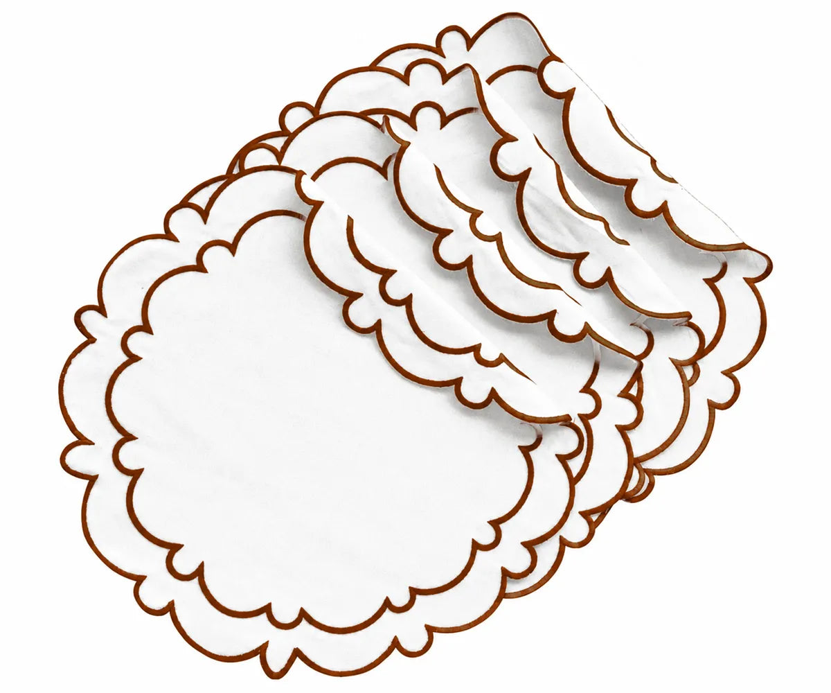 White cotton round placemat with a brown scalloped border styled on a dining table with neutral linens and autumn-inspired table accessories.