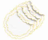 White and butter yellow round cotton placemats with scalloped edges styled on a dining table with neutral dinnerware.