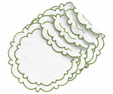 White cotton round scalloped edge placemats with sage green trim, displayed in a layered stack for elegant dining table decor.