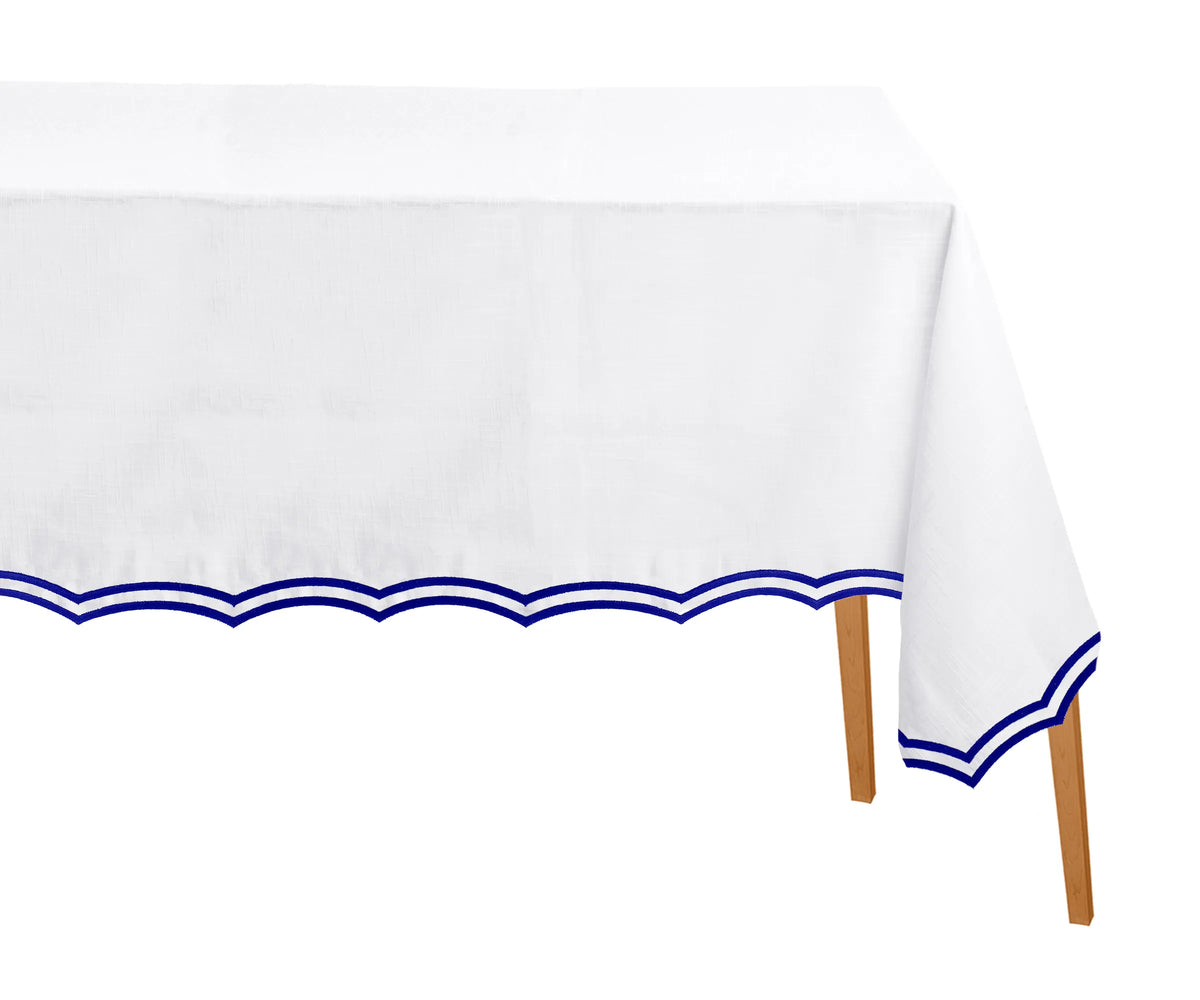 Royal blue rectangle tablecloth with scalloped embroidered edges on dining table