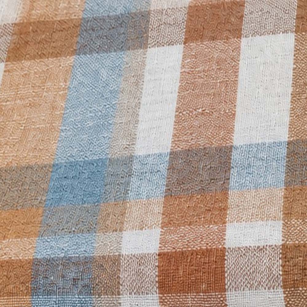 Close-up fabric swatch of a rust brown, light blue, and beige plaid pattern