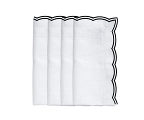 Black scalloped edge napkins placed on a formal dinner setting