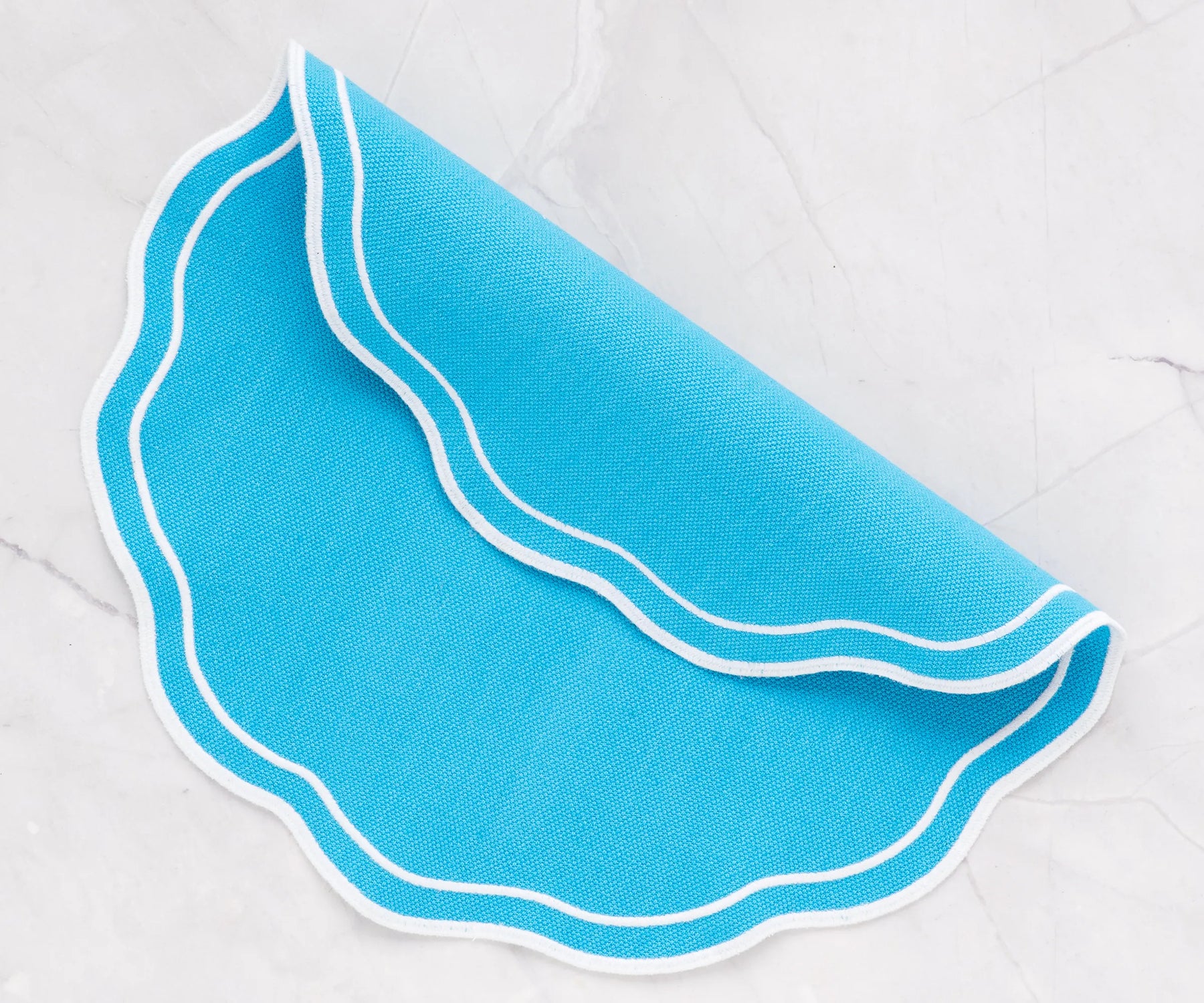 Durable light blue placemat with scalloped edges, washable and reusable