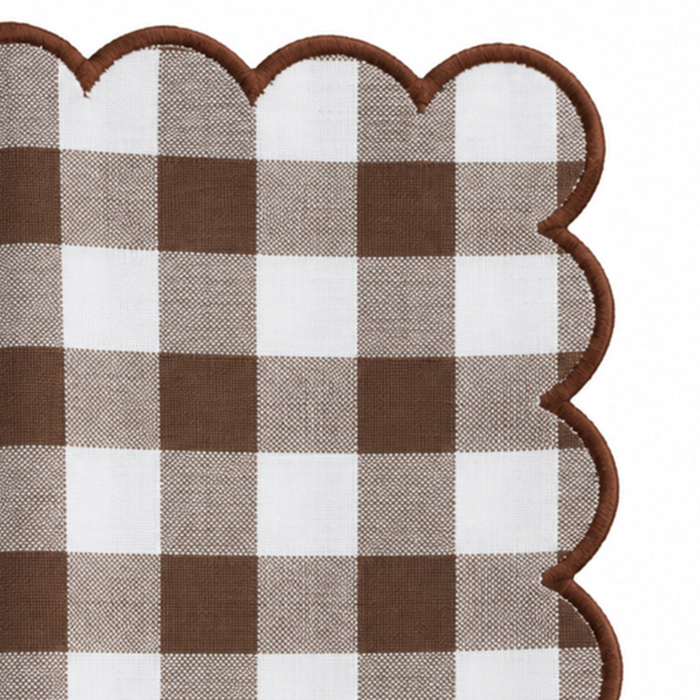 Close-up of brown and white gingham cotton dinner napkin with matching red scalloped embroidered edge