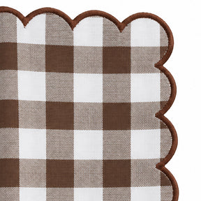 Close-up of brown and white gingham cotton dinner napkin with matching red scalloped embroidered edge