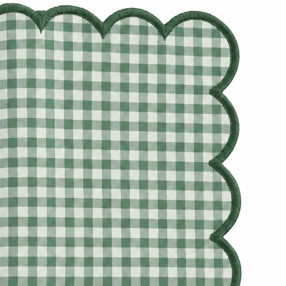 Close-up of green and white gingham cotton dinner napkin with dark green scalloped embroidered edge.