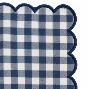Close-up of navy blue and cream gingham cotton dinner napkin with matching red scalloped embroidered edge
