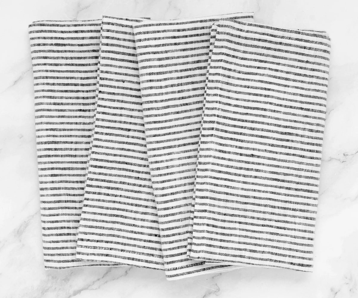 Set of 12 black linen napkins displayed flat to show size and uniform stitching