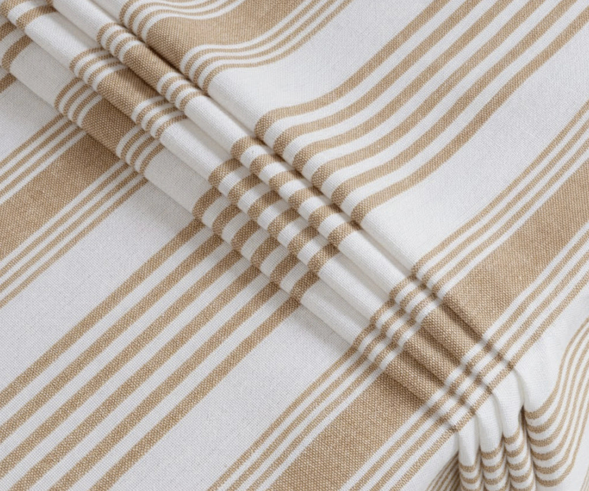 Beige and white striped rectangular tablecloth with elegant drape on dining table