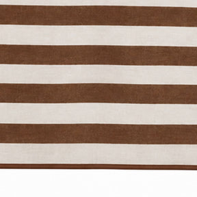 A close-up of a striped textile or rug with alternating horizontal bands of medium brown and warm off-white.