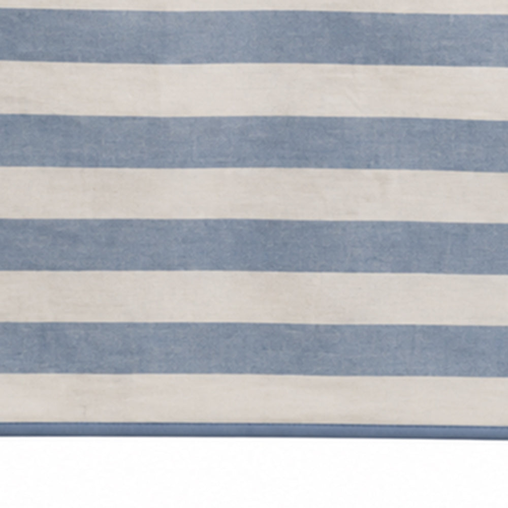 A close-up of a striped textile or rug with alternating horizontal bands of dusty blue and warm off-white.