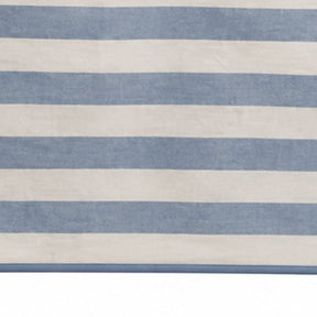 A close-up of a striped textile or rug with alternating horizontal bands of dusty blue and warm off-white.