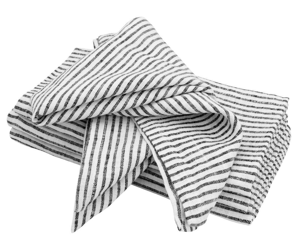Stack of folded black linen napkins neatly arranged on a dining table setup