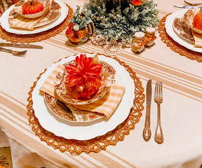 Outdoor table setting with a round tablecloth, a pumpkin, and a plate of food