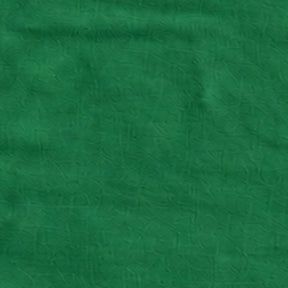 Green linen tree skirt creating a coordinated holiday look around the base of a Christmas tree