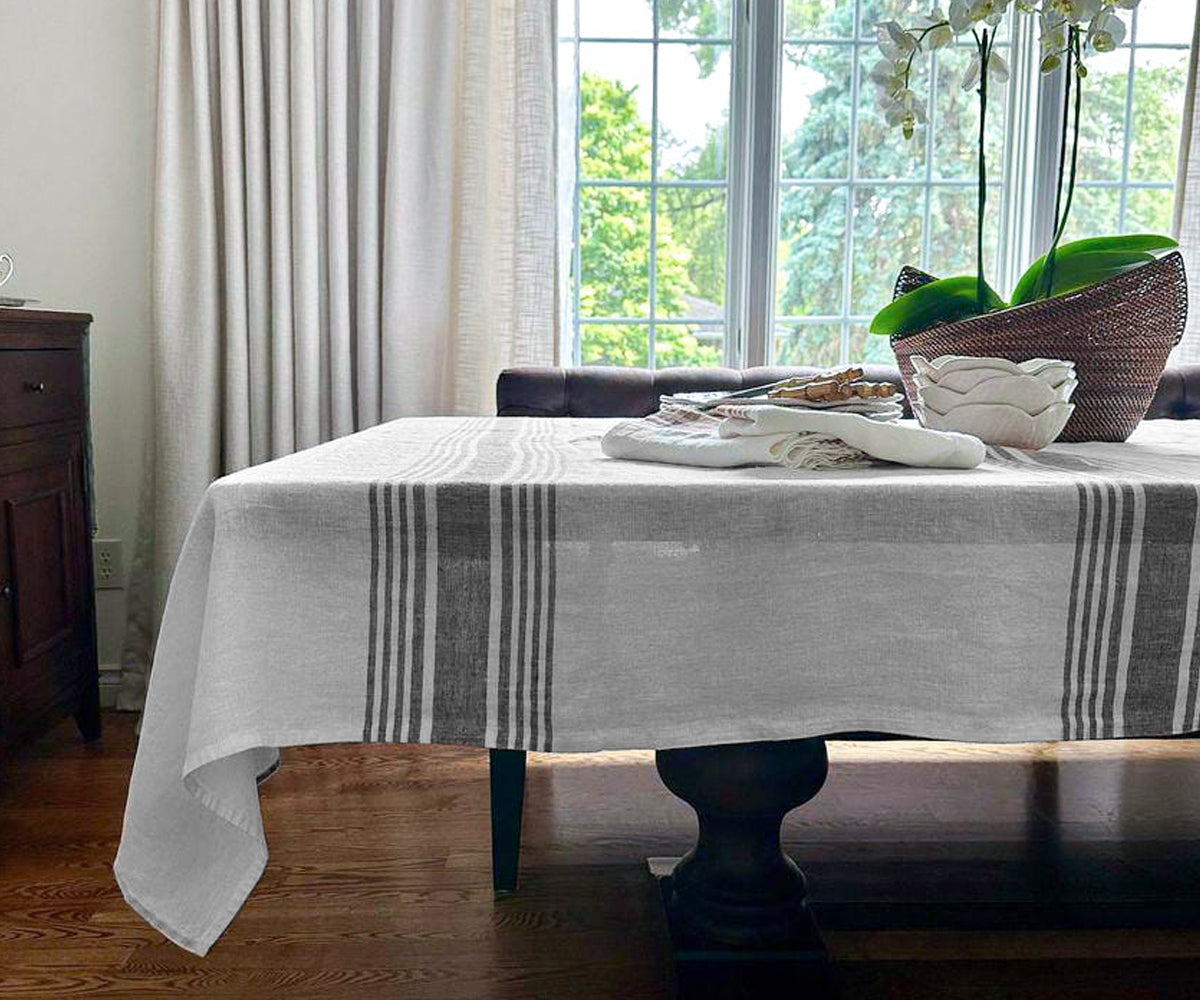 Dining table set with a white linen tablecloth and a decorative vase