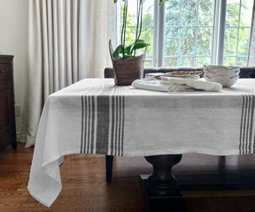 White linen tablecloth layered over a black and white runner