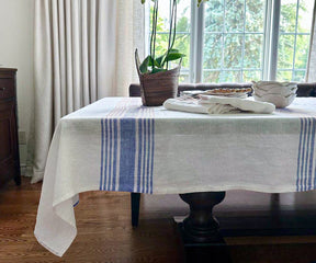 White linen tablecloth on a table with a vase of fresh flowers as a centerpiece