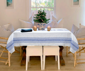 Blue and White linen tablecloth on a table with a vase of fresh flowers as a centerpiece.